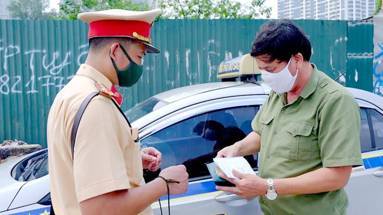 Cảnh sát giao thông đang kiểm tra giấy tờ xe ô tô, minh họa rủi ro khi xe ô tô không giấy tờ hoặc thiếu giấy tờ.