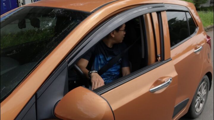 Người lái thực hiện thao tác mở cửa xe ô tô từ bên trong khoang lái một cách an toàn