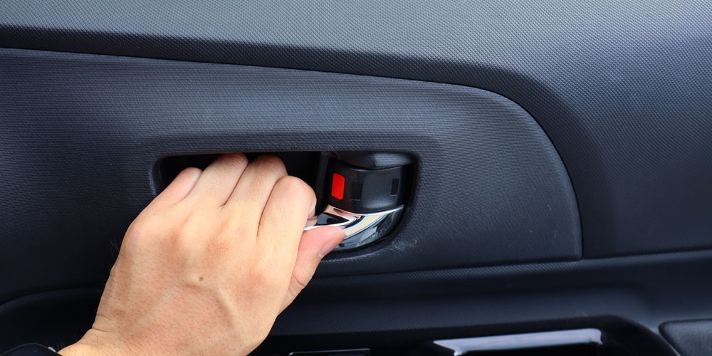 Hành khách sử dụng núm xoay màu đỏ để mở cửa xe ô tô từ hàng ghế sau