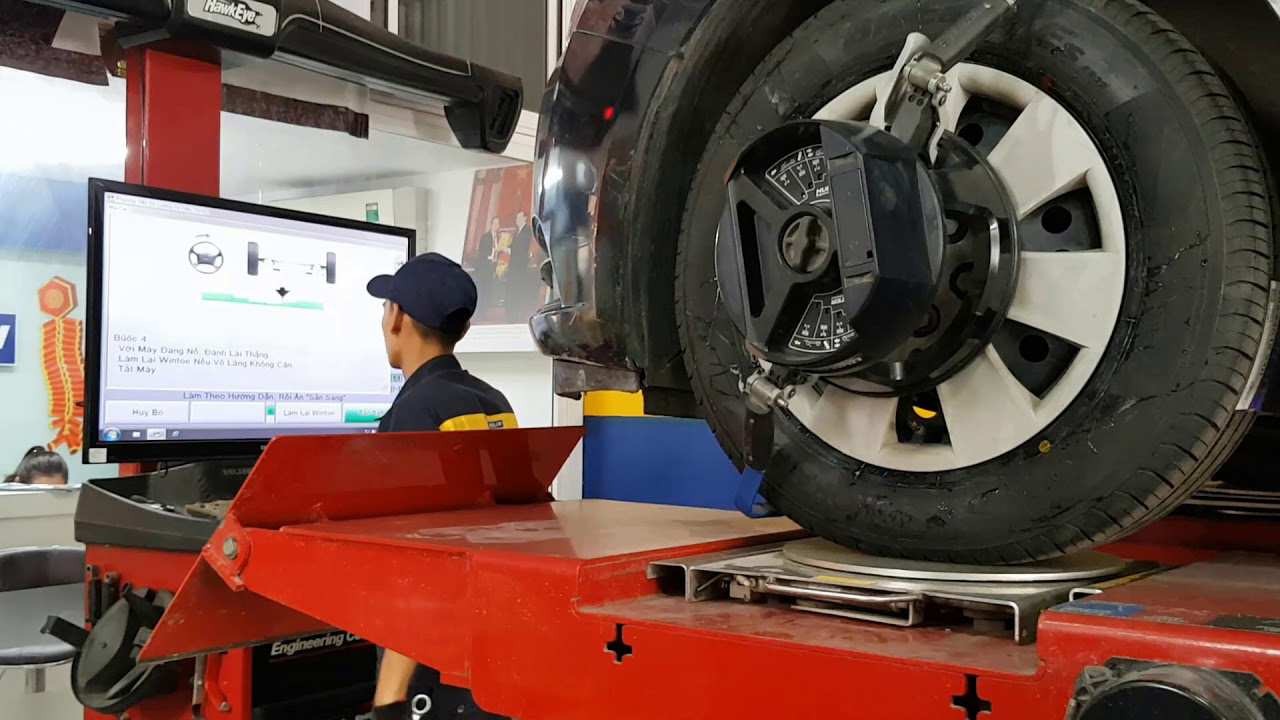 Kỹ thuật viên đang sử dụng thiết bị kiểm định xe ô tô để kiểm tra độ chụm của bánh xe, đảm bảo cân bằng và an toàn.
