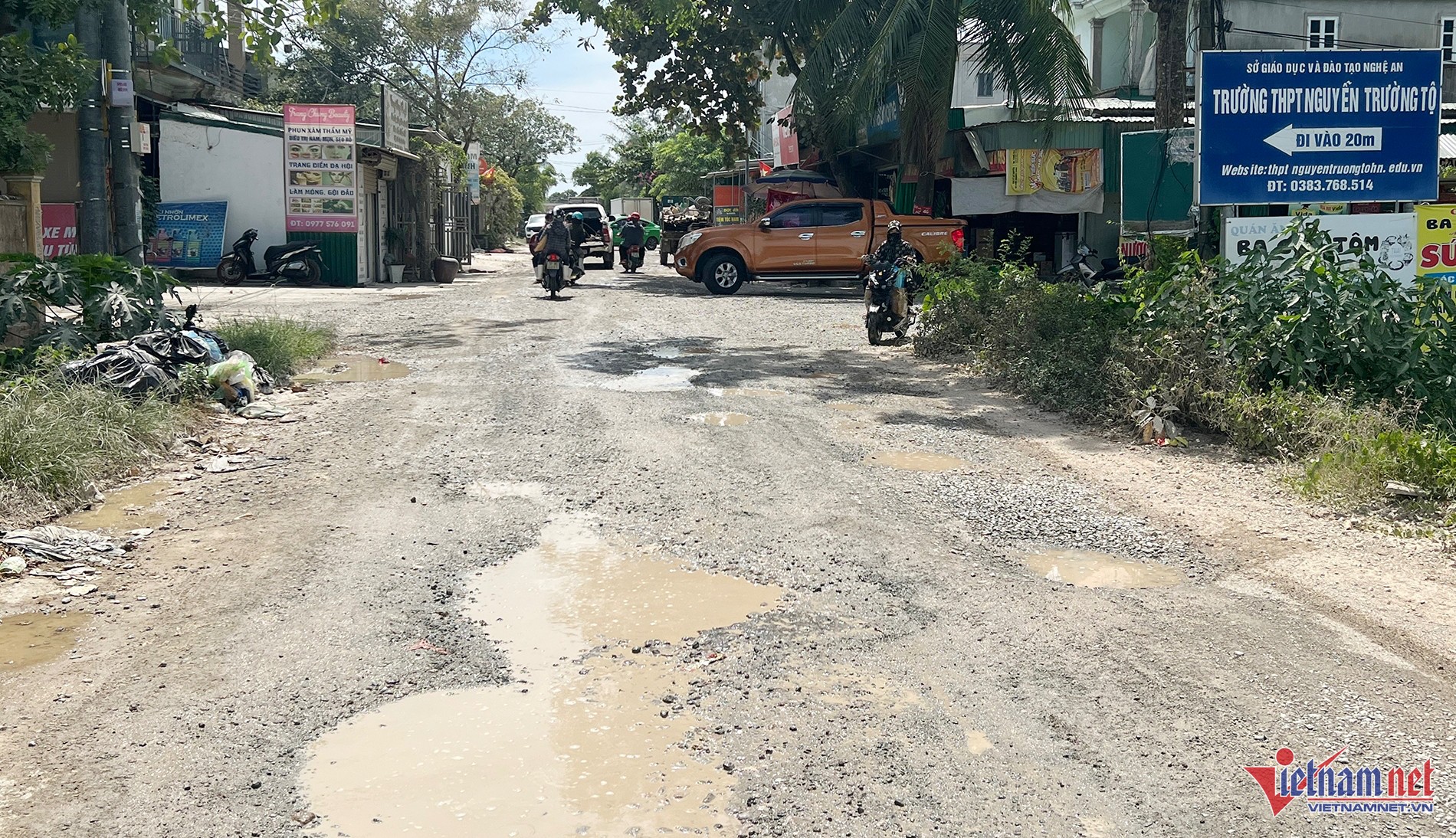 Xe tưới nước giảm bụi trên đoạn đường hư hỏng do xe ô tô chở đất tại Nghệ An
