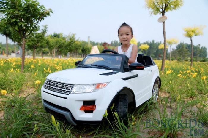 Bé gái vui vẻ lái xe ô tô điện KYD 2988 màu trắng trên sân chơi
