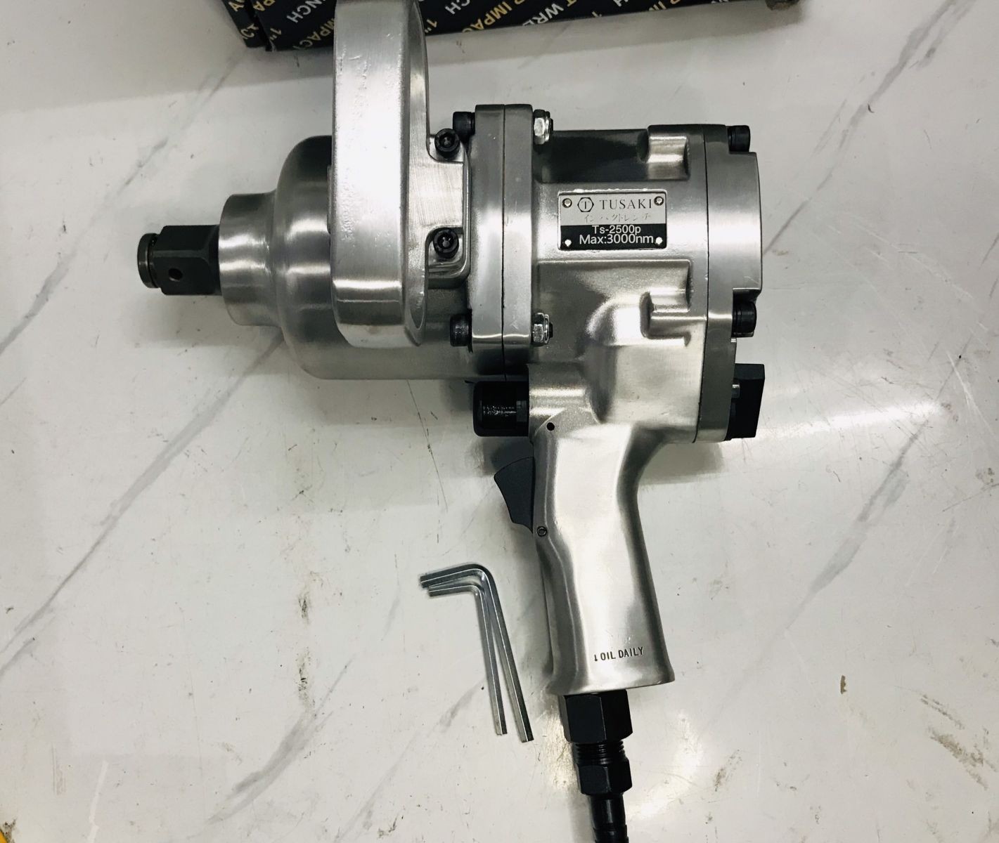 Thợ sửa chữa đang sử dụng súng TUSAKI TS-2500P để mở bu lông bánh xe ô tô tải lớn
