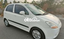 Chevrolet Spark Van 2014 màu trắng trên đường phố đô thị, thể hiện khả năng vận hành linh hoạt và tiết kiệm nhiên liệu