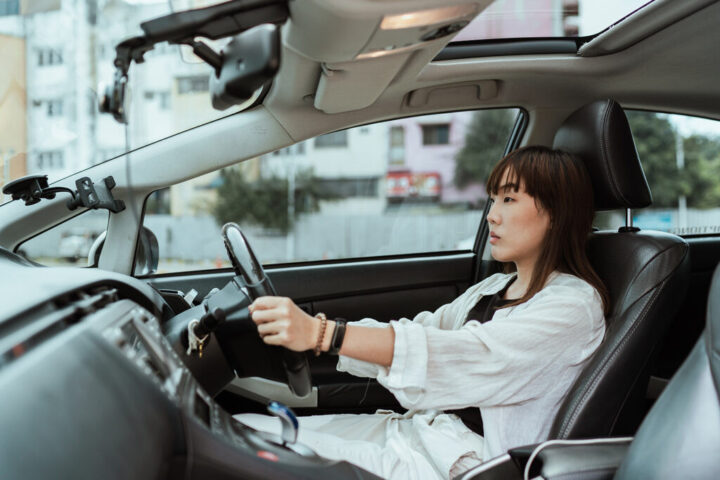 Phụ nữ lái xe ô tô tập trung trên đường, giữ an toàn giao thông