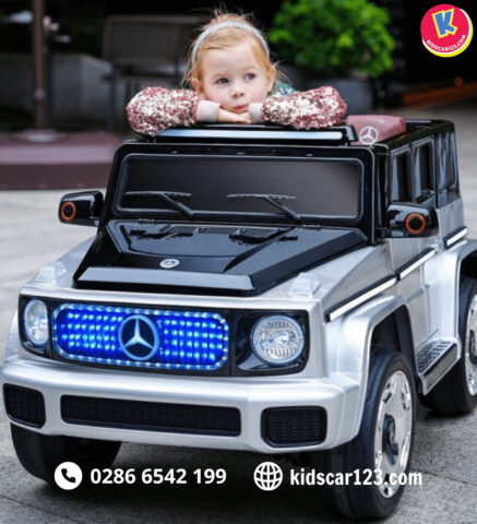 Bé trai vui vẻ lái siêu xe ô tô điện màu vàng trên sân chơi