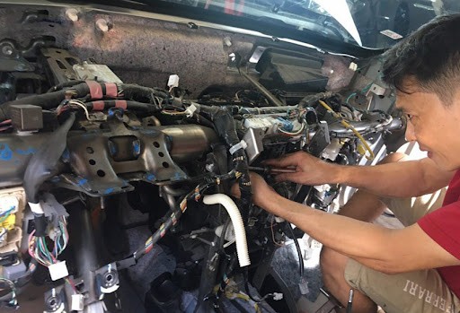 Kỹ thuật viên chuyên nghiệp đang kiểm tra động cơ xe ô tô cũ tại Hà Nội