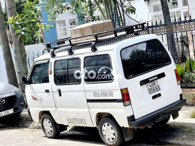 Xe ô tô Suzuki Ertiga 7 chỗ cũ màu trắng đang đỗ trên đường, minh họa kinh nghiệm chọn mua xe cũ.