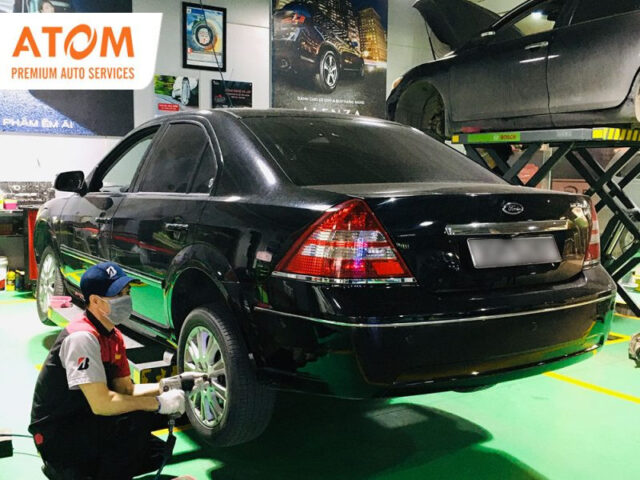 Kỹ thuật viên đang kiểm tra gầm xe ô tô Ford trong quá trình bảo dưỡng định kỳ