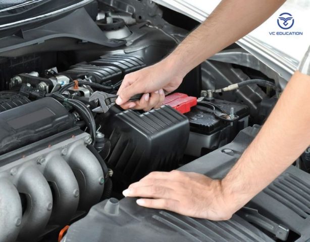 Kỹ thuật viên đang kiểm tra động cơ xe ô tô cũ trong quá trình bảo dưỡng xe