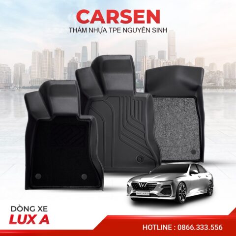 Người đàn ông đang cẩn thận tháo lót sàn xe ô tô màu đen bằng dụng cụ chuyên dụng, tập trung vào chi tiết