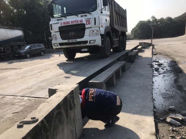 Xe tải đang được cân trọng lượng tại trạm cân điện tử để kiểm tra tải trọng hàng hóa, một trong những lỗi của xe ô tô cần được giám sát