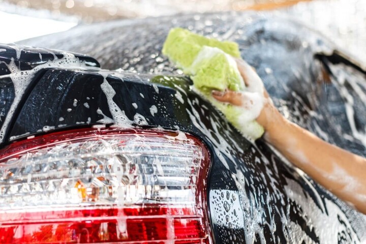 Dịch vụ rửa xe ô tô quận 12: Xe đang được xịt nước làm mềm bụi bẩn