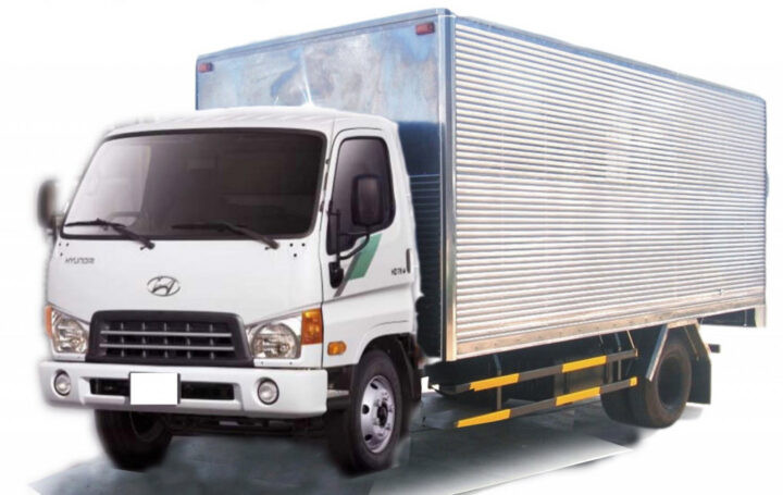 Xe ô tô tải màu trắng hiện đại, tượng trưng cho một xe ô tô tải lúc 7 giờ 30 phút, trên đường đô thị