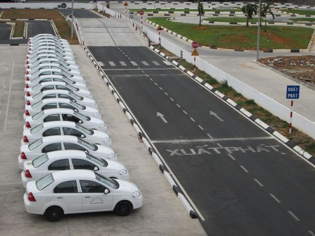 Hình ảnh một nhóm học viên đang thực hành kinh nghiệm học lái xe ô tô Đà Nẵng dưới sự hướng dẫn của giáo viên.
