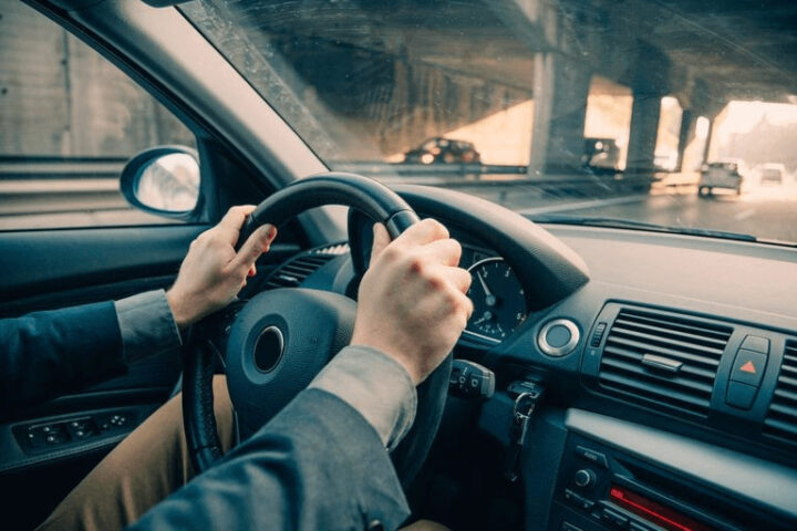 Người lái xe ô tô tập trung điều khiển vô lăng, thể hiện hành trình bo bí bo bo bo tôi lái xe ô tô một cách chuyên nghiệp