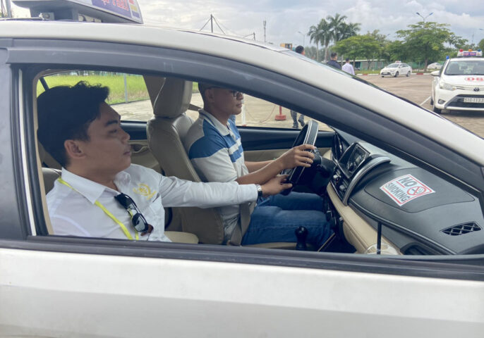 Hình ảnh một học viên đang học lái xe ô tô dưới sự hướng dẫn của giáo viên tại sân tập lái ở Phú Yên.