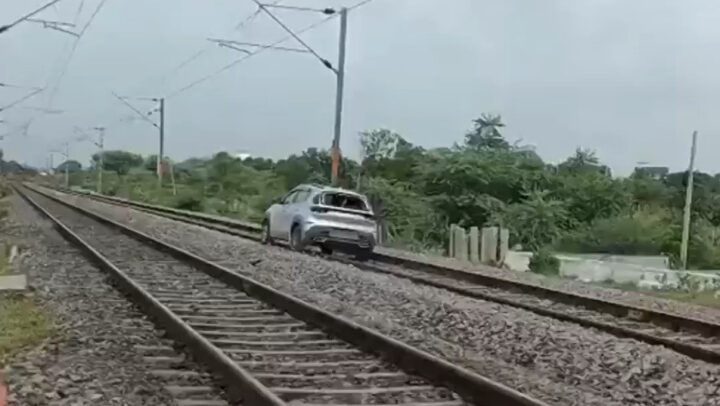 Chiếc xe Kia Sonet di chuyển trên đường ray tàu hỏa, minh họa nguy hiểm khi xe ô tô chạy trên đường ray.