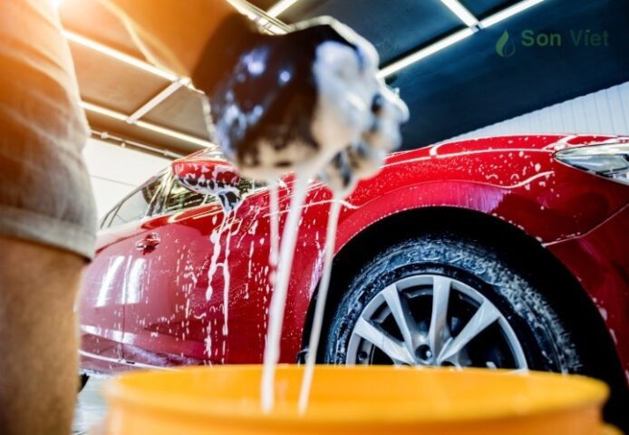Người đàn ông đang rửa sạch bụi bẩn trên xe ô tô bằng xà phòng rửa xe ô tô chuyên dụng, đảm bảo an toàn cho lớp sơn.