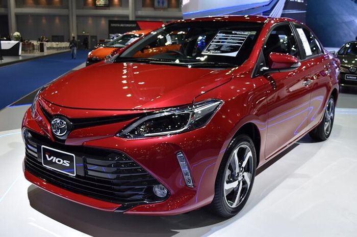 Xe Toyota màu trắng đang di chuyển trên đường phố, thể hiện sự phổ biến của hãng trong top hãng xe ô tô Việt Nam