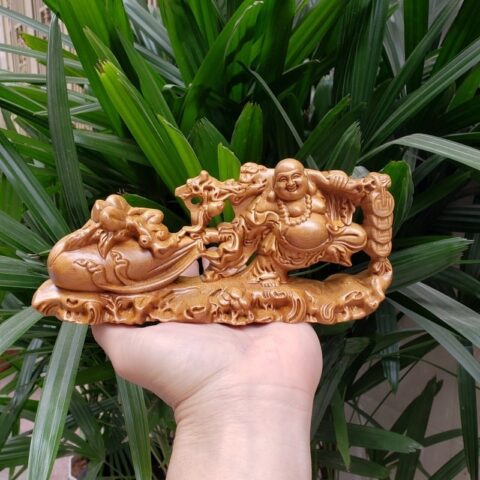 Tượng gỗ Phật Di Lặc cười trên taplo xe ô tô mang ý nghĩa may mắn và tài lộc, là lựa chọn nên để gì trên xe ô tô.