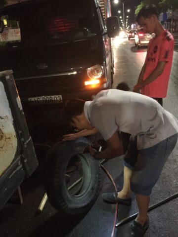 Thợ kỹ thuật đang thực hiện vá xe ô tô tại nhà, dịch vụ sửa lốp khẩn cấp tại Hải Phòng.